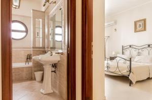 a bathroom with a sink and a bed at La Maison in Grottaglie