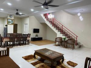 uma sala de estar com uma sala de jantar e uma escadaria em Ilham Bonda Homestay em Cukai