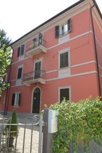 uma casa vermelha com uma cerca em frente em Rivaro Palace em Novi Ligure
