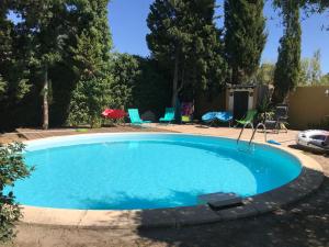 ein großer Pool in einem Garten mit Stühlen in der Unterkunft En Buena Hora in Saze
