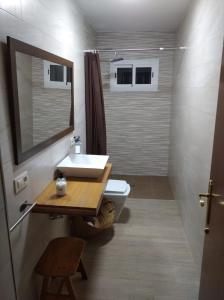 a bathroom with a sink and a toilet and a mirror at La Casa del Abuelo Jose in Marmolejo