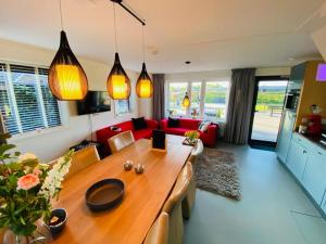 a living room with a table and a red couch at De Wolbert in Wapenveld