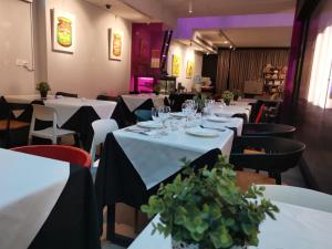 a restaurant with white tables and chairs with plants on them at Hi Hotel in Singapore