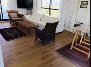 凱撒利亞的住宿－מיני פנטהאוס מול ים קיסריה，客厅配有白色的沙发和桌子
