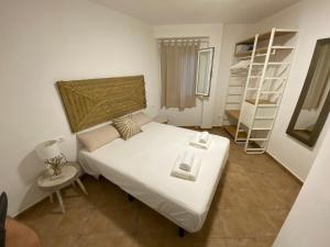 ein Schlafzimmer mit einem weißen Bett und einem Bücherregal in der Unterkunft Bella Paula in Es Pujols