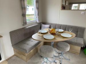 uma mesa e duas cadeiras com pratos e copos de vinho em Haggerston Castle 6 Berth Caravan - Riverside 37 em Cheswick