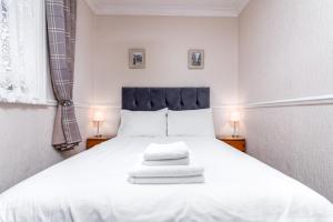 a bedroom with a large white bed with two lamps at The Roman Bath in York