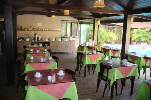 een restaurant met tafels met groene en rode tafelkleden bij Pousada Porto e Mar in Porto De Galinhas
