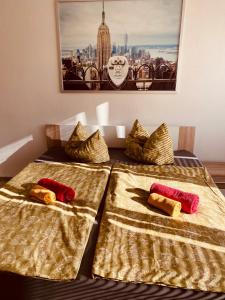 two beds with gold and red pillows on them at Apartment mit Balkon und Aussicht in Dessau