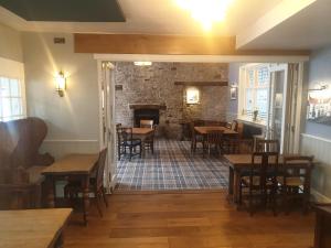 a restaurant with tables and chairs and a fireplace at The Black Swan Inn in Pickering