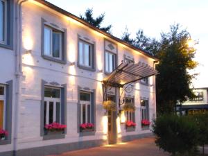 Un bâtiment blanc avec des lumières sur son côté dans l'établissement PRET A GOUTER bistro bar bed, à Heusden-Zolder