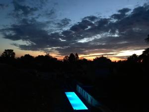 una puesta de sol con una luz azul en el cielo en De la Chambre au Jardin en Belleville-en-Beaujolais