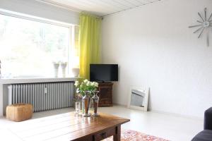 sala de estar con mesa y TV en Fewo-Bontkirchen, en Brilon