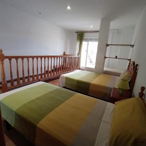 Pallaresos的住宿－Can Panxeta，一间卧室设有两张床和窗户。