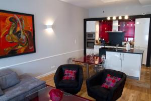 a living room with a couch and chairs and a kitchen at Appartement Rennel in Nancy