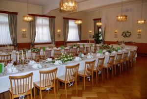 een grote feestzaal met tafels en stoelen met bloemen bij Hotel Velden Bacherlwirt in Velden am Wörthersee