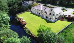 een luchtzicht op een huis met een boot op een rivier bij Ardilaun Guesthouse Self Catering in Ennis