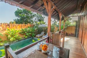 a patio with a table and a swimming pool at Green Zone Ubud Villas by Pramana Villas in Ubud