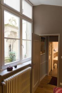 
a living room with a window and a large window at Appartement Rennel in Nancy
