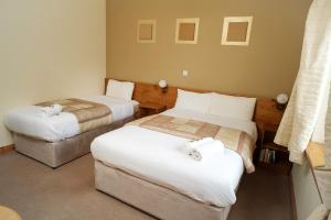 Een bed of bedden in een kamer bij Ardilaun Guesthouse Self Catering