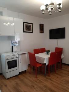 a kitchen with a table with red chairs and a white stove at Burriana in Burriana