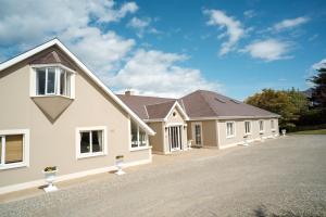 a large white house with a driveway at Ardilaun Guesthouse Self Catering in Ennis