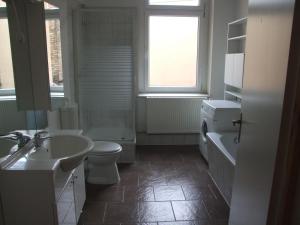 La salle de bains est pourvue d'un lavabo, de toilettes et d'une baignoire. dans l'établissement Hostel im Medizinerviertel, à Halle-sur-Saale