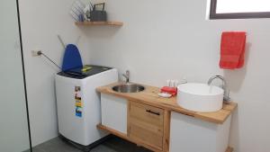 una pequeña cocina con fregadero y nevera. en Red Ochre – Large 1BR with Private Courtyard, en Port Pirie