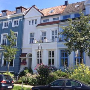 une grande maison blanche avec un toit rouge dans l'établissement Apartment im Geteviertel - citynah, à Brême