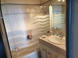 a bathroom with a sink and a glass shower at Résidence de standing la Pêcherie Spacieux T3 comme un cocon familial vue mer et sur l'avant port Sur le bout du bout de Cap d'Agde seule cap en Occitanie in Cap d'Agde +68 photos