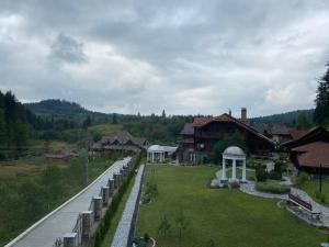 Blick auf ein Haus mit Rasen und Brücke in der Unterkunft Оранта in Schidnyzja