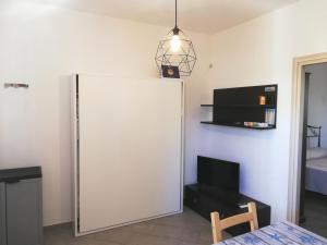 a room with a white refrigerator and a table at Kitesurf lo Stagnone in Marsala