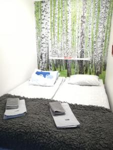 een slaapkamer met 2 bedden en een raam met bomen bij Torni-Mänttä in Mänttä