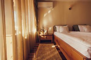 a small bedroom with a bed and a window at Denisa Boutique in Poiana Brasov