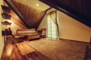 a attic living room with a window and a couch at Denisa Boutique in Poiana Brasov