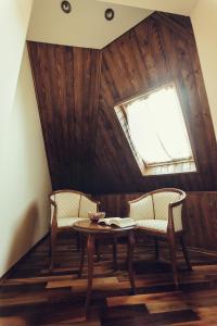 a room with a table and two chairs and a window at Denisa Boutique in Poiana Brasov