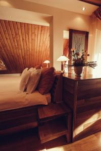 a bedroom with a bed and a desk with two lamps at Denisa Boutique in Poiana Brasov