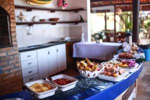 a buffet of food on a table in a kitchen at Pousada Corais do Sul in Pipa