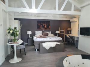 a bedroom with a bed and a living room at B&B Drenthe in Westerbork