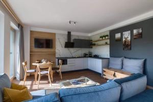 a living room with a blue couch and a table at Apartamenty Bachledzki Wierch, Zakopane in Zakopane