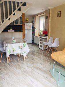 La cuisine est équipée d'une table, de chaises et d'un réfrigérateur. dans l'établissement Petite maison au cœur de l Auvergne, à Jumeaux