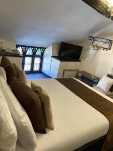 1 dormitorio con 1 cama grande y TV de pantalla plana en The Cridford Inn, en Trusham