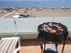 a grill on a balcony with the beach in the background at Apartamentos Varadero Sea View in Cala del Moral