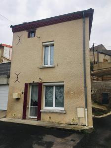 a brick house with a window and stars on it at Petite maison au cœur de l Auvergne in Jumeaux