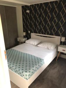 a bedroom with a white bed with a black headboard at Maison bord mer in Labenne +9 photos