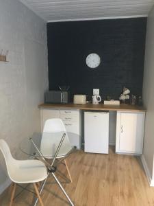 a table with a chair and a clock on a wall at Wedmore Place in Grahamstown +6 photos