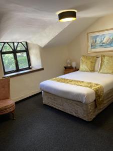 1 dormitorio con 1 cama grande y 1 silla en The Cridford Inn en Trusham