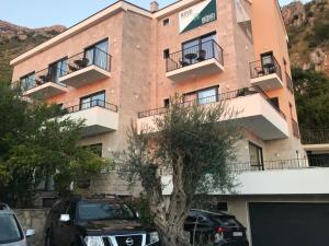 a building with cars parked in front of it at REZEVICI BOUTIQUE VILLA in Petrovac na Moru