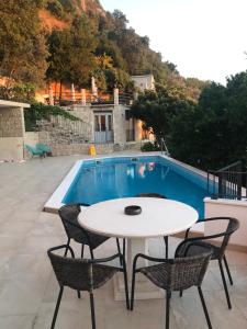 a table and chairs in front of a pool at REZEVICI BOUTIQUE VILLA in Petrovac na Moru