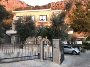 a house with a fence and a car parked in front at REZEVICI BOUTIQUE VILLA in Petrovac na Moru